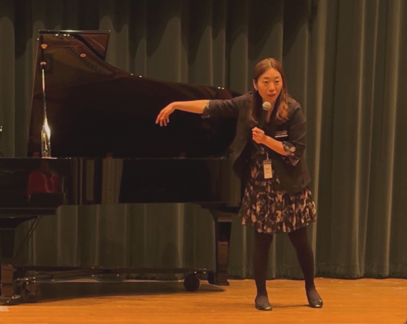 Dr. SungEun Park presenting beside a grand piano